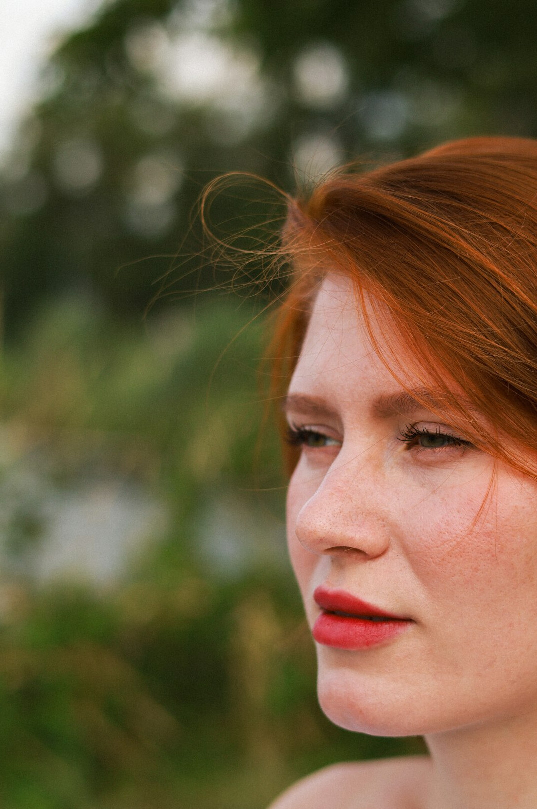 Portrait of a Central European woman in her forties with auburn hair and a cream blouse