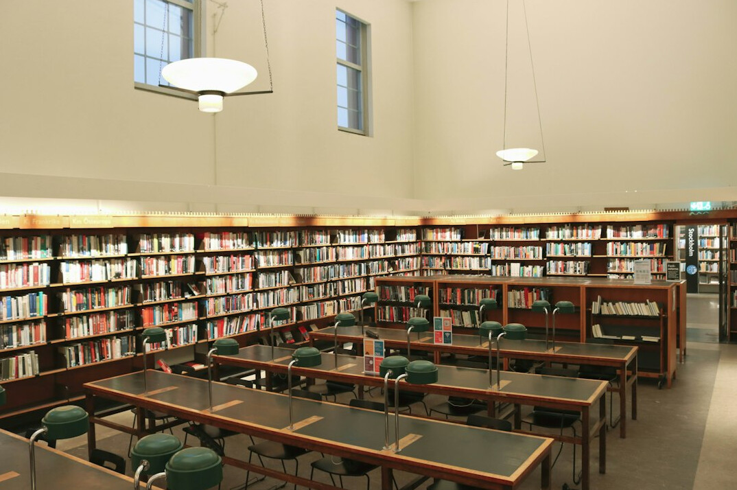 Interior of a quiet historic library with tall wooden shelves and reading tables
